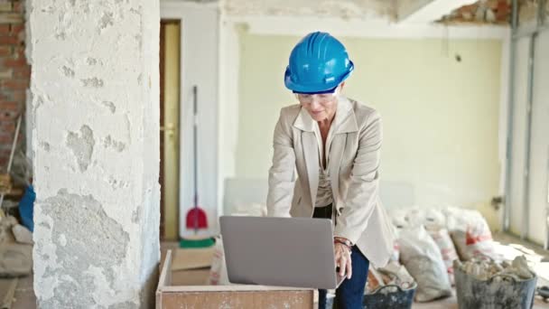 建筑工地用笔记本电脑摘下眼镜的中年金发女建筑师 — 图库视频影像