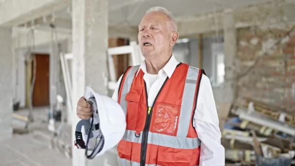 高级灰发男子建筑师在建筑工地用硬礼帽作为手扇 — 图库视频影像
