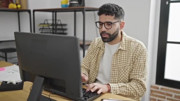 オフィスで勝者の表現で働くコンピュータを使用して若いヒスパニック系の男のビジネスワーカー — ストック動画
