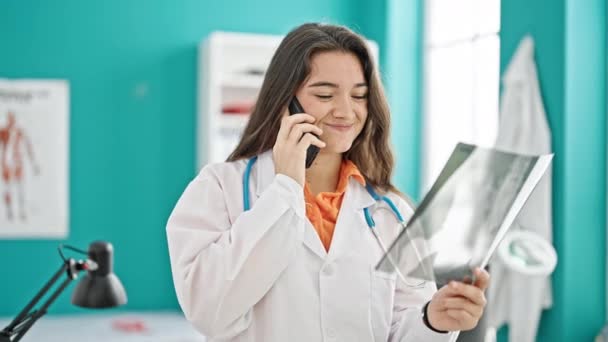 Young Beautiful Hispanic Woman Doctor Talking Telephone Holding Xray Clinic — Stock Video