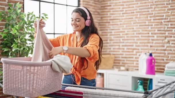 Joven Mujer Hispana Hermosa Escuchando Música Colgando Ropa Tendedero Lavandería — Vídeo de stock