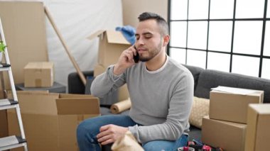 İspanyol adam gülümsüyor. Kendine güveniyor. Yeni evinde akıllı telefondan konuşuyor.