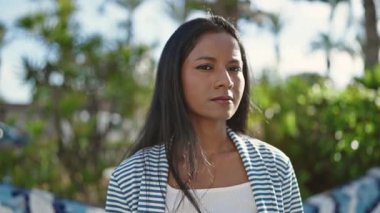 African american woman standing with serious expression at park
