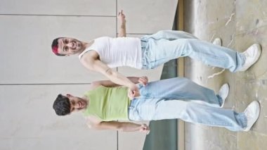 Two men couple smiling confident dancing at street