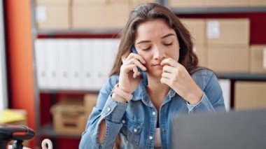 Genç, güzel, İspanyol bir kadın. İş adamı. Ofiste çalışan akıllı telefondan konuşuyor.