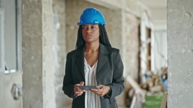 Afrika kökenli Amerikalı kadın mimar inşaat alanında dokunmatik ped kullanıyor.