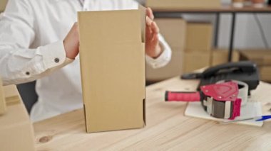 Kafkasyalı genç bir iş adamı ofiste karton kutu paketliyor.