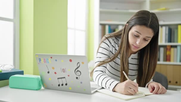 Kütüphanede Dizüstü Bilgisayar Kullanarak Notlar Alan Güzel Spanyol Bir Kız — Stok video