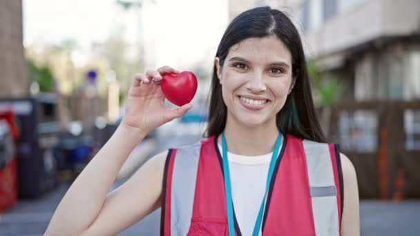 Jovem Bela Mulher Hispânica Vestindo Colete Reflexivo Segurando Coração Rua — Vídeo de Stock