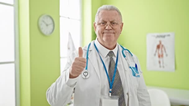 中年白发男子医生在诊所做大拇指运动 — 图库视频影像