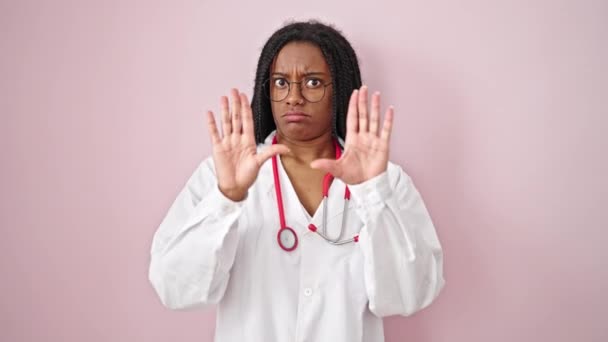 アフリカ系アメリカ人女性医師あります待ってジェスチャー上の隔離されたピンクの背景 — ストック動画