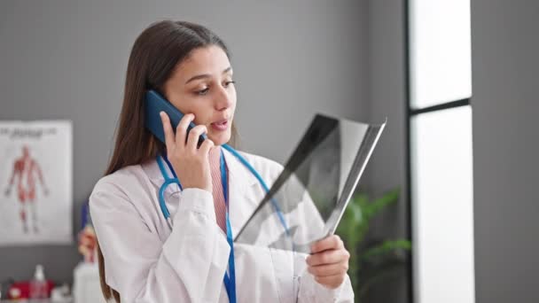 Jovem Bela Mulher Hispânica Médico Olhando Xray Falando Smartphone Clínica — Vídeo de Stock