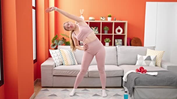 Jonge Blonde Vrouw Draagt Sportkleding Stretching Terug Thuis — Stockvideo