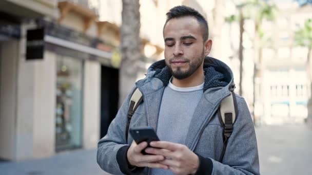 西班牙裔男子笑着自信地用智能手机在街上拍照 — 图库视频影像