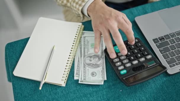 Giovane Uomo Ispanico Contando Dollari Utilizzando Calcolatrice Scrittura Note Sala — Video Stock
