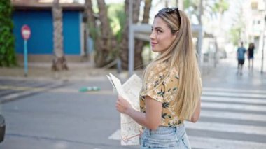Genç sarışın kadın turist gülümsüyor. Kendine güvenen şehir haritası.