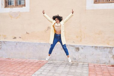 Young middle east woman excutive smiling confident jumping at street