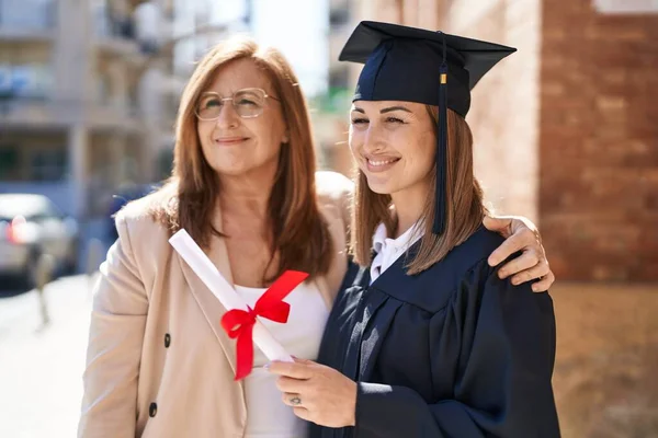 母親と娘が大学で卒業を祝うのを抱き合って — ストック写真