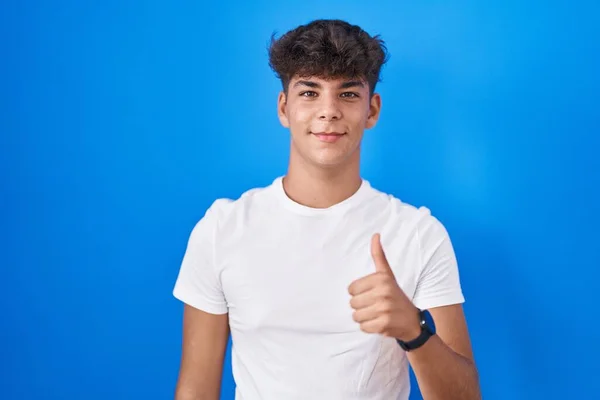 Spanyol Tinédzser Áll Kék Háttér Felett Boldog Hüvelykujjal Felemelt Kézzel — Stock Fotó