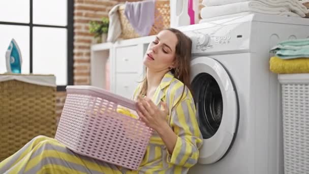 在洗衣房 年轻的金发女人提着篮子 满脸愁容 — 图库视频影像