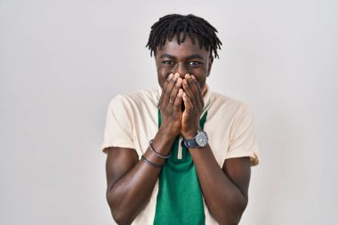 Münzevi arka planda dikilen Afrikalı adam gülüyor ve utanıyor kıkırdıyor ağızlarını ellerle kapatıyor, dedikodu ve skandal konsepti yapıyor. 