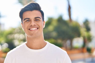 Sokakta kendinden emin gülümseyen İspanyol genç adam.