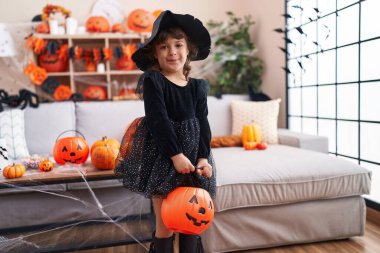 Tatlı İspanyol kız cadılar bayramı partisi veriyor evde balkabağı sepeti tutuyor.