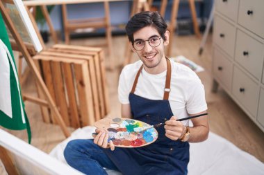 Young hispanic man artist smiling confident drawing at art studio