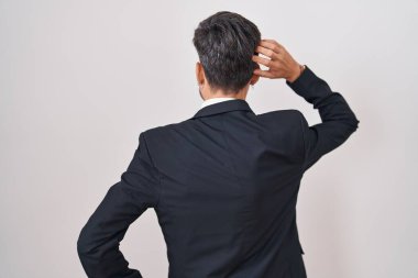 Dövmeli, takım elbiseli ve kravatlı genç İspanyol adam elleri kafasında şüpheyi geriye doğru düşünüyor. 