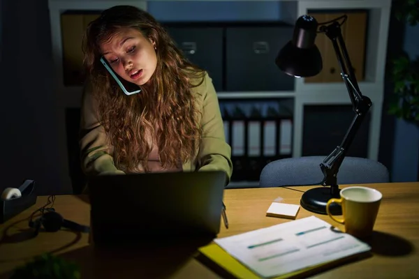 stock image Young beautiful hispanic woman business worker using laptop talking on smartphone at office