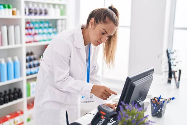 年轻美丽的惊慌失措的女药剂师使用在药店工作的计算机 — 图库照片