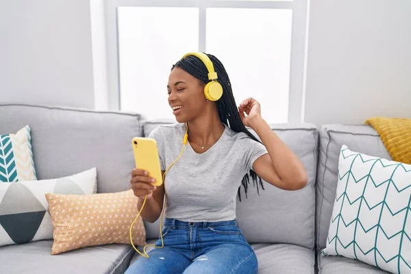 坐在家里沙发上听音乐的非裔美国妇女 — 图库照片
