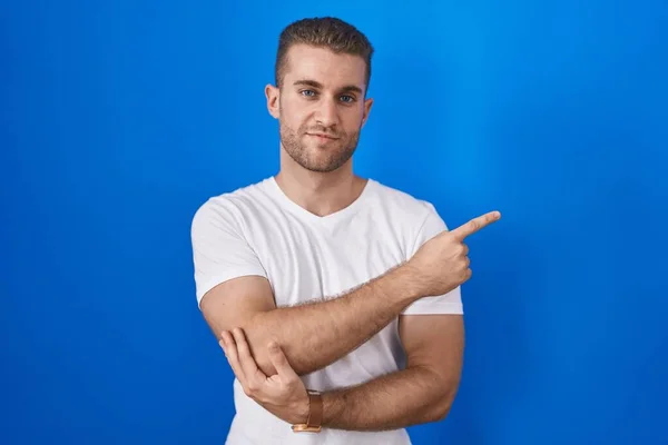 Jeune Homme Caucasien Debout Sur Fond Bleu Pointant Avec Doigt — Photo
