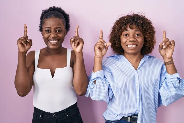 Deux Femmes Africaines Debout Sur Fond Rose Souriant Étonné Surpris — Photo