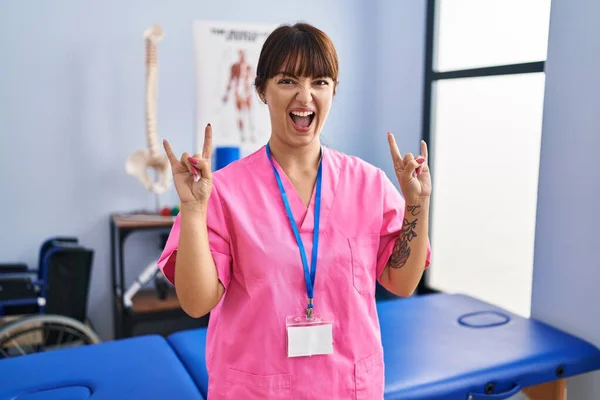 Young Brunette Woman Working Rehabilitation Clinic Shouting Crazy Expression Doing — Stock Photo, Image