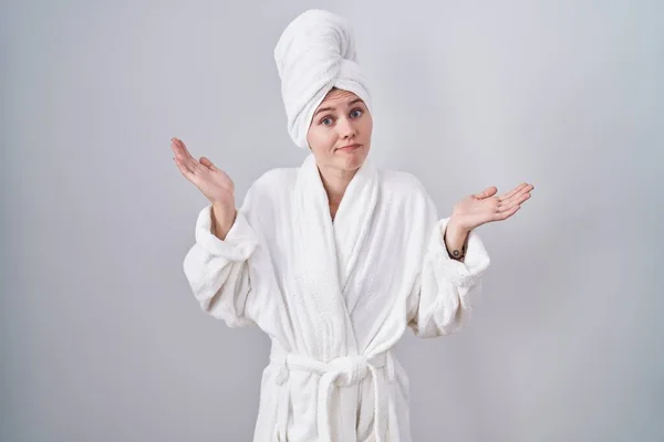 Ξανθιά Καυκάσια Γυναίκα Που Φοράει Μπουρνούζι Ανίδεη Και Μπερδεμένη Έκφραση — Φωτογραφία Αρχείου