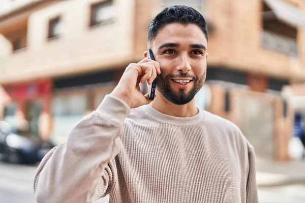 年轻的阿拉伯人微笑着 自信地在街上用智能手机交谈 — 图库照片