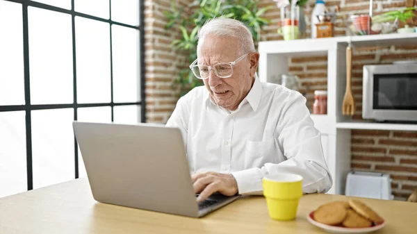Hombre Pelo Gris Senior Usando Portátil Con Gafas Comedor —  Fotos de Stock