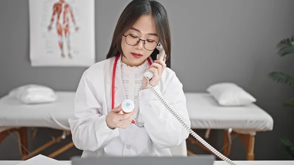 若い中国人女性医師はクリニックで電話で話す薬の治療を規定しています — ストック写真
