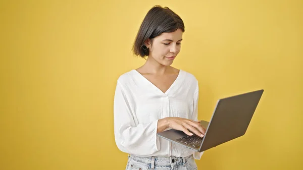 Молода Красива Іспаномовна Жінка Використовує Ноутбук Над Ізольованим Жовтим Тлом — стокове фото