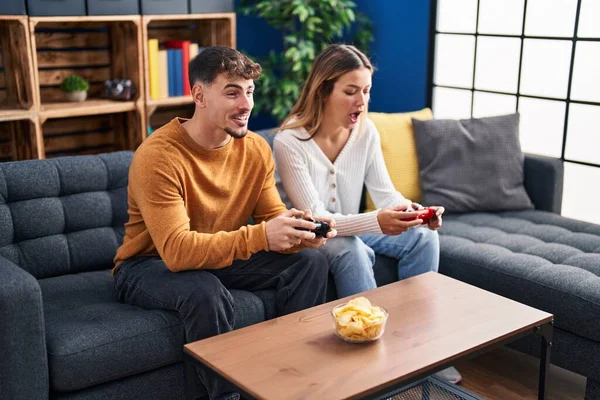 stock image Young man and woman couple playing video game sitting on sofa at home