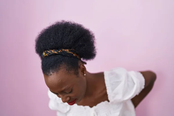 背中の痛み 手で背中に触れる 筋肉痛のピンクの背景の苦しみの上に立って巻き毛のアフリカの女性 — ストック写真