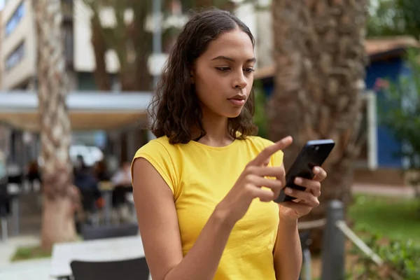 公園で真剣な表情のスマートフォンを使っている若いアフリカ系アメリカ人女性 — ストック写真