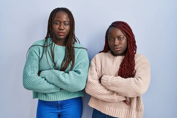 Две Африканки Стояли Синем Фоне Скептически Нервно Неодобряя Выражение Лица — стоковое фото