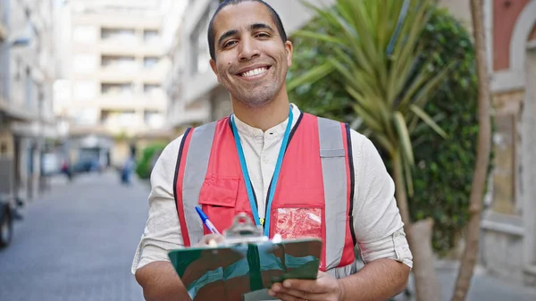 若いですヒスパニック系の男ボランティア笑顔保持クリップボードでストリート — ストック写真