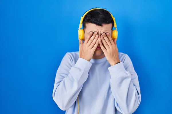 Δυαδικό Άτομο Που Ακούει Μουσική Χρησιμοποιώντας Ακουστικά Τρίβοντας Μάτια Για — Φωτογραφία Αρχείου