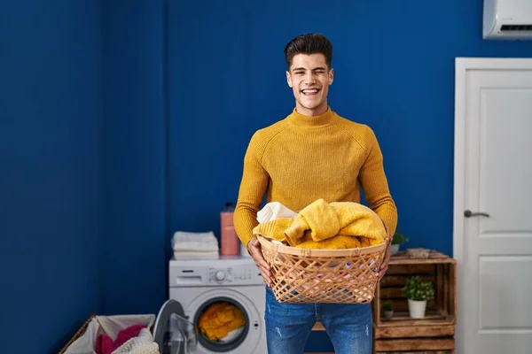 Young Hispanic Man Holding Laundry Basket Winking Looking Camera Sexy — Fotografia de Stock