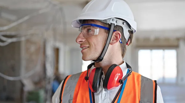 年轻的高加索人建筑师微笑着自信地站在建筑工地 — 图库照片