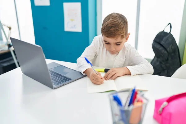 在课堂上使用笔记本电脑写笔记的可怕的男孩 — 图库照片