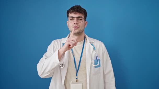 Jovem Hispânico Homem Médico Pedindo Silêncio Sobre Fundo Azul Isolado — Vídeo de Stock